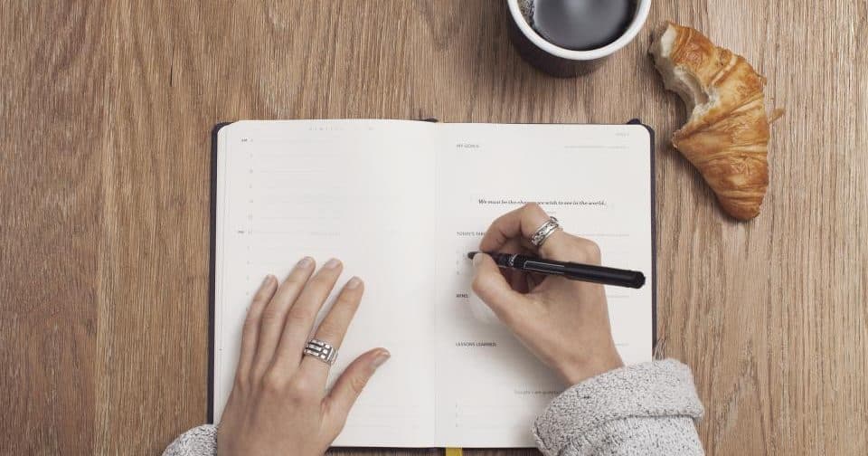 Open journal with a checklist and pen on a desk