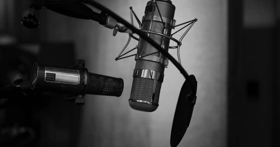 Studio microphone with a pop filter in a recording booth