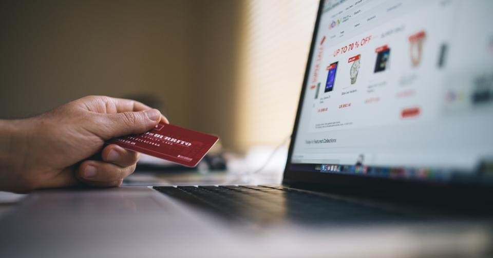 Shopper holding a credit card in front of an online store